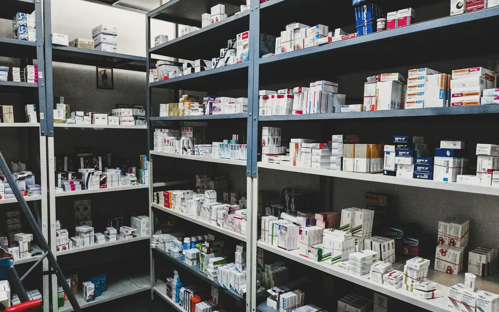 Pharmacy stockroom shelves filled with boxes of medicines