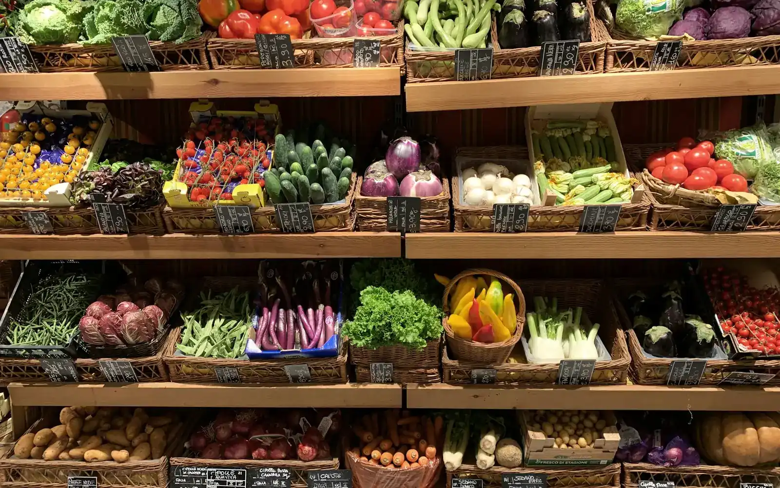 Fresh vegetables and fruit in baskets on wooden shelves