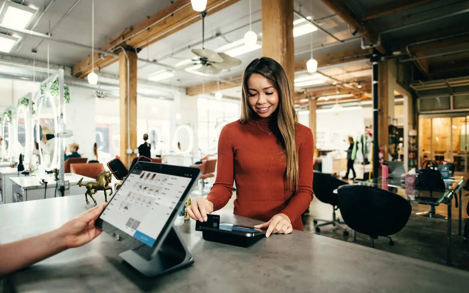 A customer paying at a salon checkout counter